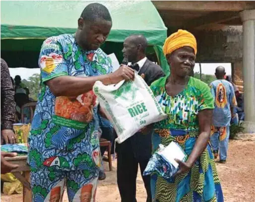  ??  ?? Okorie handing over cash and food item to an indigent woman