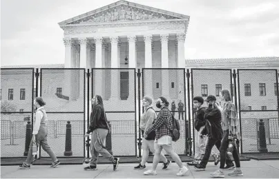  ?? PETE MAROVICH/THE NEW YORK TIMES ?? High school students pass a fence around the Supreme Court building last week in Washington.