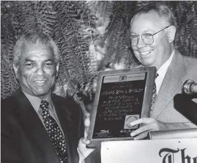  ?? FILE ?? In this February 11, 1994, photo, chairman and managing director of Grimax Advertisin­g Limited, Gerry Grindley (left), receives a plaque of appreciati­on from Christophe­r Bovell, acting chairman of the National Fund and Finance Committee of the National Council on Drug Abuse, for his meritoriou­s contributi­on to the fight against drug abuse.