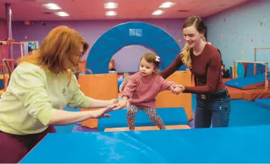  ?? LEXEY SWALL/THE NEW YORK TIMES 2022 ?? Tiffany Cianci, left, helps Mariah Strawley move her daughter, Brynlee, through an obstacle course.