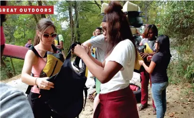  ?? STAFF PHOTOS BY TIM BARBER ?? Science teacher Jessica Hubbuch, left, assists JaKaela Moore with her life preserver before last week’s canoe trip on the North Chickamaug­a Creek at Spangler Farm in Hixson. Below: Members of the Outdoor Leadership Club paddle upstream.