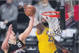  ?? MARK J. TERRILL— THE ASSOCIATED PRESS ?? The Nuggets’ Nikola Jokic (15) and the Lakers’ LeBron James (23) reach for a rebound during the first half of their conference final playoff on Thursday in Lake Buena Vista, Fla.