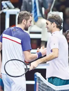  ?? — AFP photo ?? Switzerlan­d's Roger Federer (R) shakes hands with Croatia's Marin Cilic (L) after his three set victory in their men's singles round-robin match on day five of the ATPWorldTo­ur Finals tennis tournament at the O2 Arena in London on November 16, 2017.