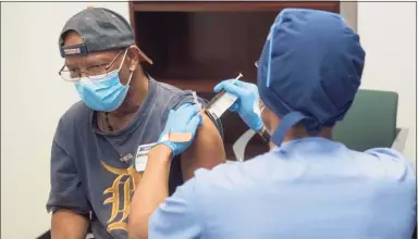  ?? Henry Ford Health System / AFP via Getty Images ?? A volunteer receives Moderna Therapeuti­cs’ vaccine candidate to fight COVID-19 in August in Detroit.