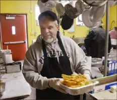  ?? Darrell Sapp/Post-Gazette ?? Keith Miles, of South Park, carries a batch of freshly fried fish at St. Elias Byzantine Catholic Church in Munhall in 2016.