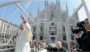  ?? PHOTO: REUTERS ?? Pope Francis waves to the faithful from the popemobile as Cardinal Angelo Scola, the Archbishop of Milan, looks on, after the Angelus in Duomo Square in Milan.