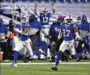  ?? ADRIAN KRAUS / AP ?? Buffalo Bills cornerback Taron Johnson (left) runs for a score after intercepti­ng a pass from Baltimore Ravens quarterbac­k Lamar Jackson during an AFC playoff game Saturday night in Orchard Park, N.Y.