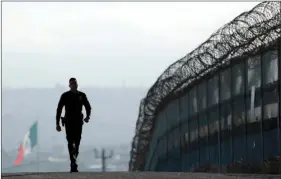 ??  ?? In this June 22, 2016, file photo, Border Patrol agent Eduardo Olmos walks near the secondary fence separating Tijuana, Mexico, (background) and San Diego in San Diego. California Gov. Jerry Brown agreed Wednesday to deploy 400 National Guard troops at...