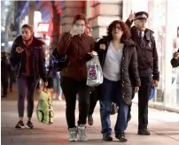  ?? AP ?? People are ushered by a police officer down a street in the west end of London after the Oxford Circus station was evacuated . —