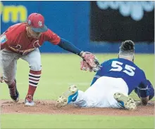  ?? RYAN REMIORZ THE CANADIAN PRESS ?? Toronto Blue Jays catcher Russell Martin (55) slides in with a double ahead of the tag by St. Louis Cardinals second baseman Kolten Wong in first-inning spring training baseball action on Monday in Montreal.