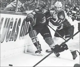  ?? Christine Cotter Associated Press ?? EMERSON ETEM and Colorado’s Brad Stuart tangle along the boards in the Ducks’ 4-2 loss. Anaheim holds on to the lead in the Pacific Division.