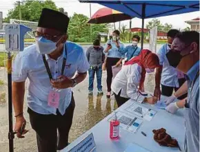  ?? BERNAMA PIC ?? GPS candidate Datuk Abdullah Saidol scanning his temperatur­e after registerin­g in MySejahter­a at the Semop state seat nomination centre in Meradong for the 12th Sarawak election yesterday.