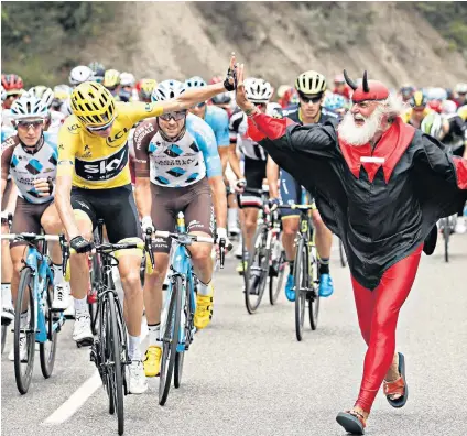  ??  ?? High five: Chris Froome is greeted by the legendary Didi Senft, the Tour Devil, during yesterday’s stage
