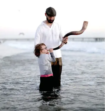  ?? (Illustrati­ve photo, Lucy Nicholson/Reuters) ?? THE SHOFAR and prayers are supposed to help us with introspect­ion but that is not always easy. A father holds a shofar for his daughter to blow.