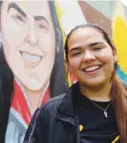  ??  ?? IGUALISTAS. Adriana Díaz posa al lado de un mural en su honor hecho por unos artistas de Bayamón.