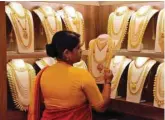  ?? — Reuters ?? A saleswoman picks gold necklaces to show it to a customer inside a jewellery shop in Kochi.