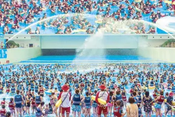  ?? REUTERS ?? People swim under a giant screen at an indoor swimming pool on a hot day in Chengdu, China on Saturday.