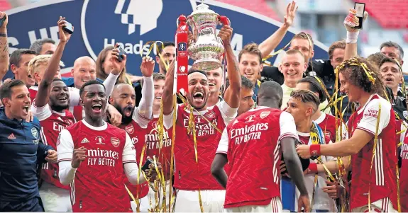  ?? Pictures: PA. ?? Gunning for more glory: Pierre-Emerick Aubameyang lifts the FA Cup – eventually – after his goals helped Arsenal to victory.