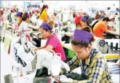  ?? VIREAK MAI ?? Garment workers piece together clothes at the Grand Twin Internatio­nal Factory in Phnom Penh in 2014.