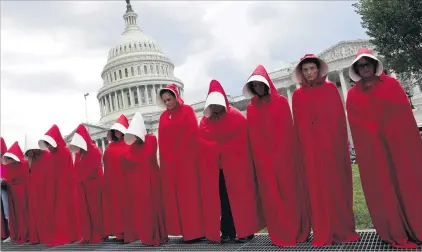 ?? PHOTO: REUTERS ?? Seeing red . . . Women dressed as handmaids from the novel, film and television series The Handmaid’s Tale demonstrat­e against cuts for Planned Parenthood in the Republican Senate healthcare Bill at the Capitol in Washington yesterday.