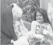  ?? BILL TIERNAN AP ?? Karrissa Nash sits on Signing Santa’s lap Tuesday at the MacArthur Mall in Norfolk, Va.