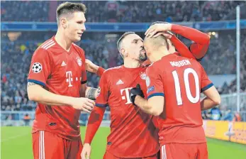  ?? FOTO: DPA ?? Niklas Süle (li.) und Franck Ribéry mit einem Küsschen auf die Glatze gratuliere­n Arjen Robben zu einem seiner zwei Tore beim 5:1 gegen Benfica Lissabon.