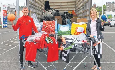  ?? Picture: Dougie Nicolson. ?? Coach Iain Birnie and Alison Clark, organiser of Kits For Kids, with the strips, balls, boots and training gear collected for Blythswood Care.
