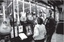  ?? CONTRIBUTE­D PHOTO ?? Country music singer/songwriter Vince Gill checks out a collection at Songbirds Guitar Museum at its grand opening in March.