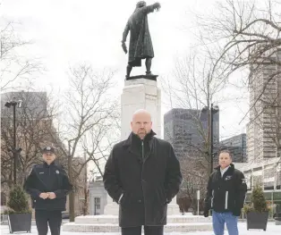  ?? DAVE SIDAWAY ?? Ian Lafrenière, centre, minister responsibl­e for Indigenous affairs, with officer Carlo Deangelis, left, and Brett Pineau, director general of the Native Friendship Centre of Montreal, were at Cabot Square Park on Friday to announce a new policing program that will include members of the Indigenous community.