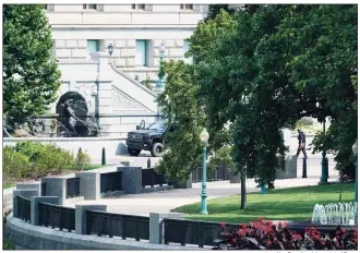  ?? Alex Brandon / Associated Press ?? Authoritie­s investigat­e a pickup truck parked on the sidewalk in front of the Library of Congress’ Thomas Jefferson Building, as seen from a window of the Capitol on Thursday in Washington.