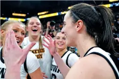  ?? ABBIE PARR/THE ASSOCIATED PRESS ?? Iowa guard Caitlin Clark, right, celebrates with teammates Sunday after their 94-89 overtime win against Nebraska in the final of the Big Ten women’s tournament in Minneapoli­s.