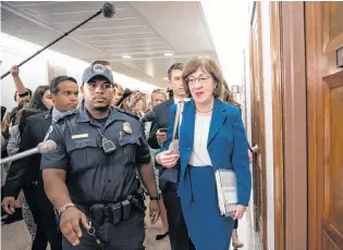  ?? AP PHOTO ?? Sen. Susan Collins, R-maine, is escorted by U.S. Capitol Police as she is met by cameras and reporters asking about embattled Supreme Court nominee Brett Kavanaugh, on Capitol Hill in Washington on Wednesday.