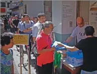  ??  ?? 香港特首林鄭月娥11­日發表施政報告當天，有市民在街頭領取《施政報告》。 （中通社）