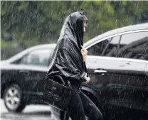  ?? PHOTO: REUTERS ?? Downpour . . . A woman walks during heavy rain.