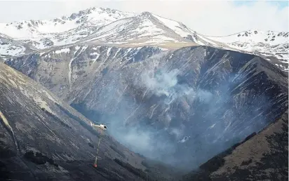  ?? PHOTO: CRAIG BAXTER ?? Mounting risk . . . A helicopter heading to fight the Ohau fire passes a burntout gully on Monday. Researcher­s say there is no silver bullet to prevent fires in what is an increasing­ly fireprone area.