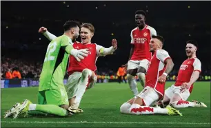  ?? AFP ?? Arsenal players celebrate their Champions League last 16 second leg win over Porto on March 12. —