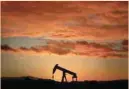  ?? — Reuters ?? An oil pump jack is seen at sunset outside Scheibenha­rd, France.