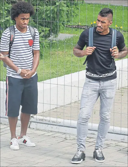  ?? FOTO: AP ?? Paulinho y Willian, esperando ayer el autobús para ir al aeropuerto de Kazán tras la eliminació­n de Brasil en el Mundial de Rusia