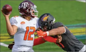  ?? (AP/Matthew Hinton) ?? American team quarterbac­k Kellen Mond of Texas A&M throws as National team offensive lineman Spencer Brown of Northern Iowa defends during the Senior Bowl on Saturday in Mobile, Ala. Mond threw for 173 yards and two touchdowns to earn MVP honors.