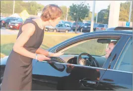  ??  ?? Charles County Superinten­dent Kimberly Hill speaks with a driver about safe driving at La Plata High School Wednesday morning, as part of the “We Care” safe driving campaign.