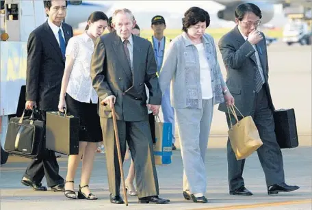  ?? Koichi Kamoshida Getty Images ?? CHARLES ROBERT JENKINS arrives in Tokyo with his wife, Hitomi Soga, in 2004. Jenkins had been held in North Korea since 1965 after abandoning his U.S. Army unit in South Korea and heading north across the border, a decision he’d regret for the rest of...