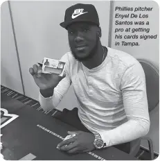  ??  ?? Phillies pitcher Enyel De Los Santos was a pro at getting his cards signed in Tampa.