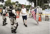  ?? CARL JUSTE cjuste@miamiheral­d.com ?? Miami-Dade police escort a pro-Trump demonstrat­or away from Black Lives Matter protesters Sunday. Both groups were at the 7900 block of Northwest 154th Street in Miami Lakes.