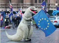  ?? TOLGA AKMEN / AFP / GETTY IMAGES ?? A demonstrat­or waves a European Union (EU) flag in a protest outside in central London on Monday.