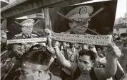  ?? Sakchai Lalit / Associated Press ?? Myanmar citizens living in Thailand wave signs in protest of the coup and Gen. Min Aung Hlaing.