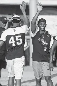  ??  ?? Chris Paul, right, greets Jazz point guard Donovan Mitchell, who also went deep during the celebrity softball game.