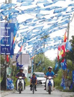  ??  ?? ... Barisan Nasional flags lining the road in Kampung Permatang Tengah, Bukit Mertajam.