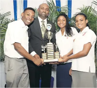  ??  ?? Minister of Science, Energy and Technology Dr Andrew Wheatley poses with students from Campion College, who topped the 16-19 age category of the science competitio­n in the PCJ Schools Energy Programme. The winning team of Malik Graham (left), Je’nine...