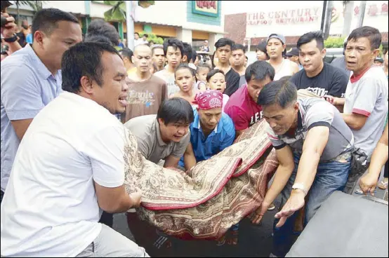  ?? MIGUEL DE GUZMAN ?? Men carry the body of Abdul Munap Akok to a waiting vehicle after unidentifi­ed assailants shot him in Manila yesterday.