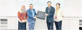  ?? ?? PENGHARGAA­N: Fung (dua kanan) menyampaik­an cenderamat­a kepada Ronatkinso­n (dua kiri) sambil disaksikan (dari kiri) pegawai SSM Cawangan Sarawak dan Penasihat dan Pensyarah YAC Wong Kai Lu.